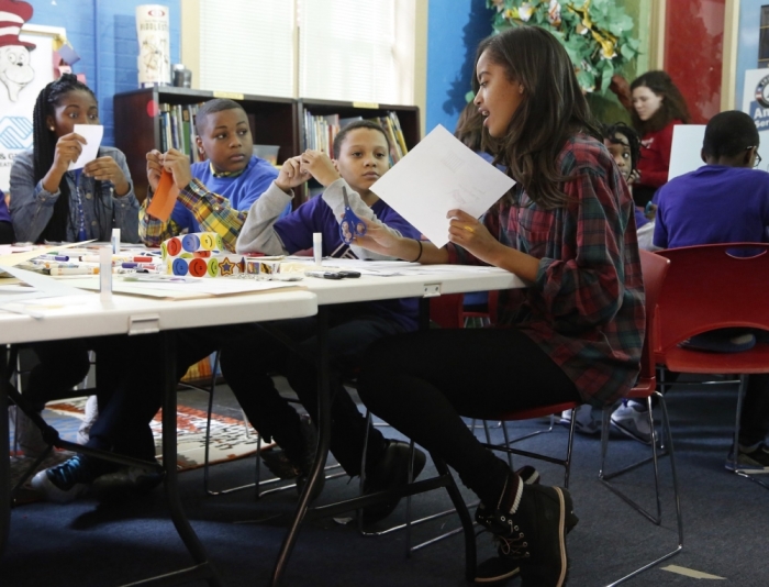 Malia Obama (R), the eldest daughter of U.S. President Barack Obama, works on a literacy project with children during a day of service at the Boys & Girls Club of Greater Washington, in celebration of the Martin Luther King Jr. holiday in Washington, January 19, 2015.