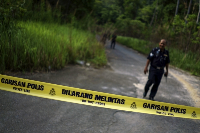 A Malaysian policeman leaves the site of the place where human remains were found, near an abandoned human trafficking camp, in the jungle close to the Thailand border at Bukit Wang Burma in northern Malaysia, May 29, 2015. Malaysian police have exhumed the remains of four people from the trafficking camp at Bukit Wang Burma, a hill near Wang Kelian village. There is a police checkpoint and barracks only a few hundred meters from the jungle path that leads up to the Bukit Wang Burma camp. The camps are located in a remote but sensitive border area that many state agencies are tasked with monitoring.