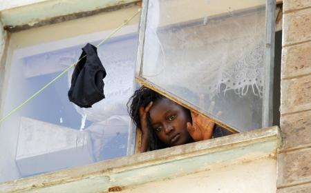 A student at the University of Nairobi looks down from the window at the Kimberly ladies hostels at the Kikuyu campus near the capital Nairobi, Kenya, April 12, 2015. A Kenyan student died and more than 100 others were injured as they fled after a electricity transformer explosion before dawn on Sunday triggered fears that their campus was being attacked, officials said. Students jumped from windows at their University of Nairobi residence halls in a stampede that underlined growing tensions just over a week after gunmen stormed another university campus.