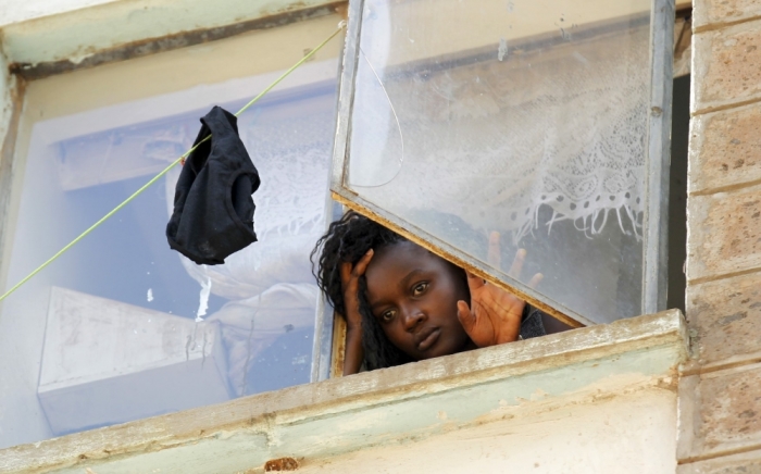 A student at the University of Nairobi looks down from the window at the Kimberly ladies hostels at the Kikuyu campus near the capital Nairobi, Kenya, April 12, 2015. A Kenyan student died and more than 100 others were injured as they fled after a electricity transformer explosion before dawn on Sunday triggered fears that their campus was being attacked, officials said. Students jumped from windows at their University of Nairobi residence halls in a stampede that underlined growing tensions just over a week after gunmen stormed another university campus.