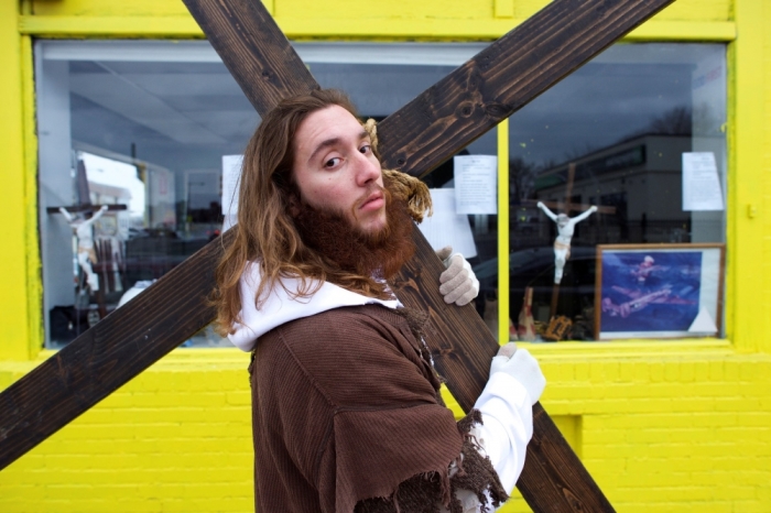 Michael Grant, 28, 'Philly Jesus,' poses for a portrait in front of a store window featuring crucifixes with the 12 foot cross he carried 8 miles through North Philadelphia to LOVE Park in Center City as part of a Christmas walk to spread the true message of the holiday in Philadelphia, Pennsylvania December 20, 2014. As many as a half dozen others joined him for numerous miles as he trekked southward down Broad Street. Some shouted 'Praise Jesus!' and 'Thank you for doing this!' at the sight. Nearly everyday for the last 8 months, Grant has dressed as Jesus Christ, and walked the streets of Philadelphia to share the Christian gospel by example. He quickly acquired the nickname of 'Philly Jesus,' which he has gone by ever since.