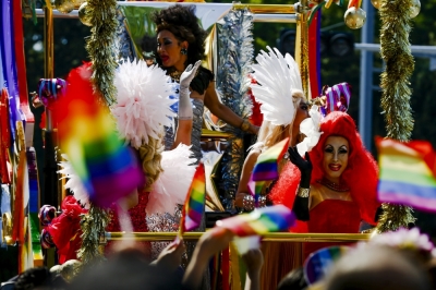 Men in drag costumes wave from a float to participants during the Tokyo Rainbow Pride parade in Tokyo April 26, 2015.