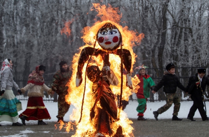 Children walk around a burning effigy of Lady Maslenitsa, as they celebrate Maslenitsa, or Pancake Week, in Stavropol February 21, 2015. Maslenitsa is widely viewed as a pagan holiday marking the end of winter and is celebrated with pancake eating, while the Orthodox Church considers it as the week of feasting before Lent.