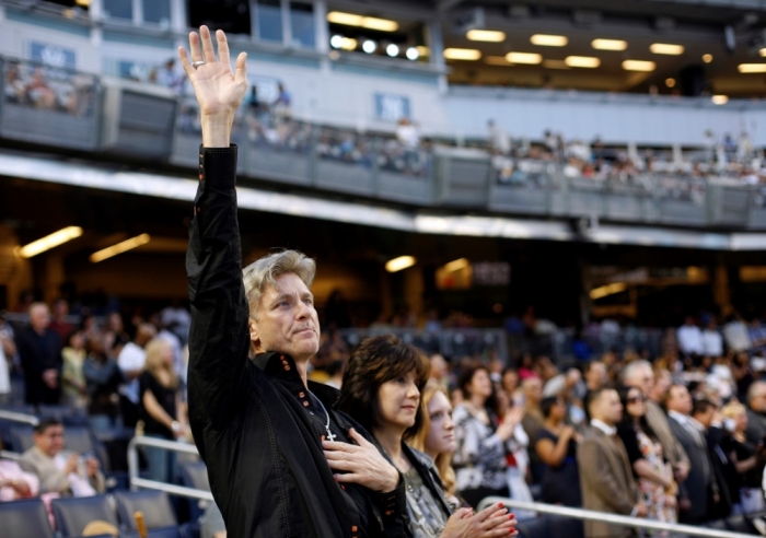 A man raises his hand in prayer during the 'Historic Night of Hope' by the evangelist Joel Osteen ministries at Yankee Stadium in New York, April 25, 2009. The service was the first ever non baseball event at the new Yankee Stadium.