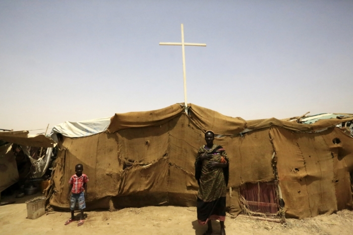 People from South Sudan stand near a tent used as a church at a railway station camp, where they have spent the last four years, in Khartoum, May 11, 2014.