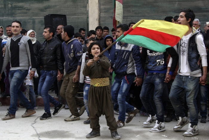 A Kurdish boy waves a Kurdish flag during celebrations after it was reported that Kurdish forces took control of the Syrian town of Kobani, in Sheikh Maksoud neighborhood of Aleppo, January 27, 2015. Kurdish forces battled Islamic State fighters outside Kobani on Tuesday, a monitoring group said, a day after Kurds said they took full control of the northern Syrian town following a four-month battle.