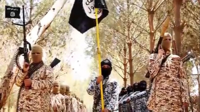 Armed with massive assault rifles and rocket launchers, ISIS-trained children stand under the notorious black flag used by Islamist groups in this video released in June 2015.