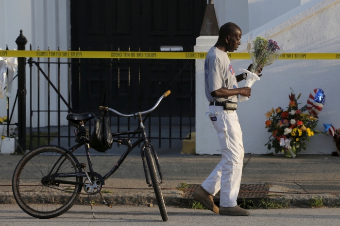 Larry Gorham rode his bicycle to pay his respects outside the Emanuel African Methodist Episcopal Church in Charleston, South Carolina, June 19, 2015, two days after a mass shooting left nine dead during a Bible study at the church.