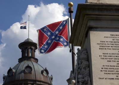 The U.S. flag and South Carolina state flag flies at half staff to honor the nine people killed in the Charleston murders as the confederate battle flag also flies on the grounds of the South Carolina State House in Columbia, SC June 20, 2015.