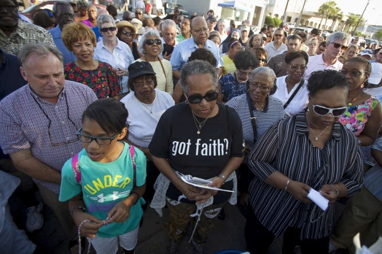 People gather to pray in the late afternoon outside the Emanuel African Methodist Episcopal Church in Charleston, June 21, 2015. The church reopened on Sunday for its first service since nine people at a Bible-study meeting were shot dead on Wednesday by suspect Dylann Roof, a 21-year-old white man with a criminal record.