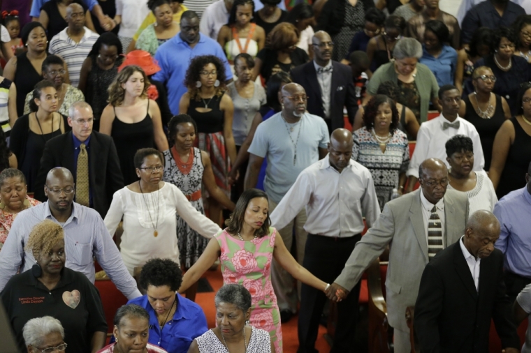 Parishioners hold hands and sing during services at the Emanuel African Methodist Episcopal Church in Charleston, South Carolina, June 21, 2015. The church held its first service since a mass shooting left nine people dead during a Bible study.