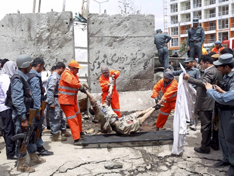 Municipality workers remove the body of a dead Taliban insurgent as security forces carry out an inspection at the site of an attack near the Afghan parliament in Kabul, Afghanistan, June 22, 2015. A Taliban suicide bomber and six gunmen attacked the Afghan parliament on Monday, wounding at least 19 people and sending a plume of black smoke across Kabul, as a second district in two days fell to the Islamist group in the north.