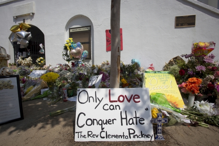 A sign is pictured at a makeshift memorial for victims of a mass shooting, outside the Emanuel African Methodist Episcopal Church in Charleston, South Carolina, June 22, 2015. Dylann Roof, 21, was arrested on Thursday and charged with nine counts of murder for gunning down members of a Bible study group at the church, nicknamed 'Mother Emanuel,' after sitting with them for an hour on Wednesday night.