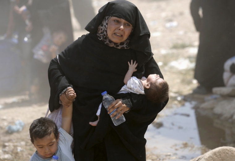 A Syrian refugee woman crosses into Turkey with her children at the Akcakale border gate in Sanliurfa province, Turkey, June 15, 2015. On Sunday, Turkish authorities reopened the border after a few days of closure, a security source said, adding that they expected as many as 10,000 people to come across.