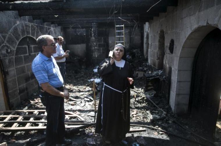 A nun stands at the scene of a fire in the Church of Loaves and Fishes on the shores of the Sea of Galilee in northern Israel, June 18, 2015. An arson attack on Thursday gutted part of the church at the site where Christians believe Jesus performed a miracle by feeding 5,000 people with five loaves of bread and two fish on the shore of the Sea of Galilee, the Israeli fire brigade said.