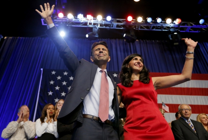 Republican presidential candidate and Louisiana Governor Bobby Jindal waves with his wife Supriya Jolly after formally announcing his campaign for the 2016 Republican presidential nomination in Kenner, Louisiana, June 24, 2015.