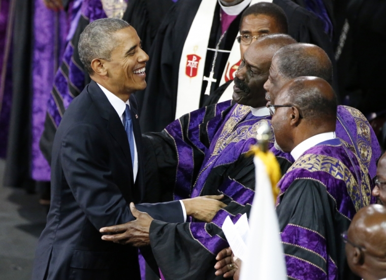 U.S. President Barack Obama is greeted by church leaders on stage after completing his eulogy in honor of the Rev. Clementa Pinckney during funeral services for Pinckney in Charleston, South Carolina, June 26, 2015. Pinckney is one of nine victims of a mass shooting at the Emanuel African Methodist Episcopal Church.