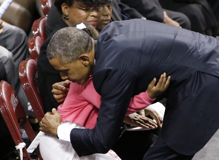 U.S. President Barack Obama bends down to hug Malana Pinckney after completing his eulogy for her father Rev. Clementa Pinckney during funeral services for Pinckney in Charleston, South Carolina, June 26, 2015. Pinckney is one of nine victims of a mass shooting at the Emanuel African Methodist Episcopal Church.