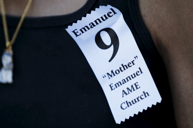 A woman wears an 'Emanuel 9' ribbon to the funeral for the Reverend Clementa Pinckney in Charleston, South Carolina, June 26, 2015. South Carolina will take a step forward in healing the wounds of last week's mass shooting when President Barack Obama arrives on Friday to deliver the eulogy for Pinckney, the pastor of the historic church where the attack took place. Pinckney was one of the nine victims of the mass shooting at the church.
