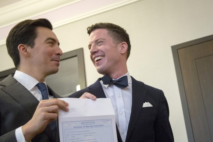 Rodrigo Zamora (L) and Ashby Hardesty show their marriage license to friends at the New York City clerk's office after their wedding in Manhattan in New York, June 26, 2015. The Supreme Court ruled on Friday that the U.S. Constitution provides same-sex couples the right to marry, handing a historic triumph to the American gay rights movement. Hardesty and Zamora waited until the Supreme Court decision before getting married to each other. They were engaged two years ago at the Stonewall Inn the last time the U.S. Supreme Court decided on same sex marriage.