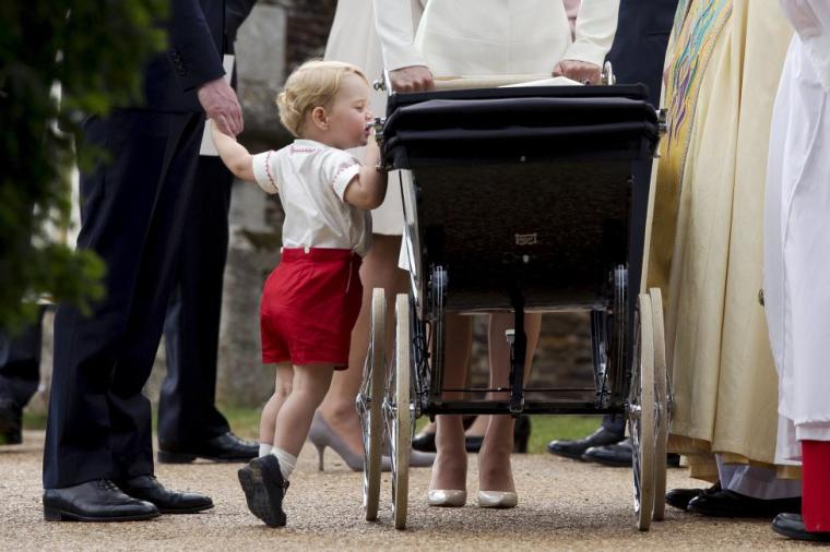 Britain's Prince George looks into the pram of his sister Princess Charlotte after her christening at the Church of St. Mary Magdalene in Sandringham, Britain July 5, 2015.