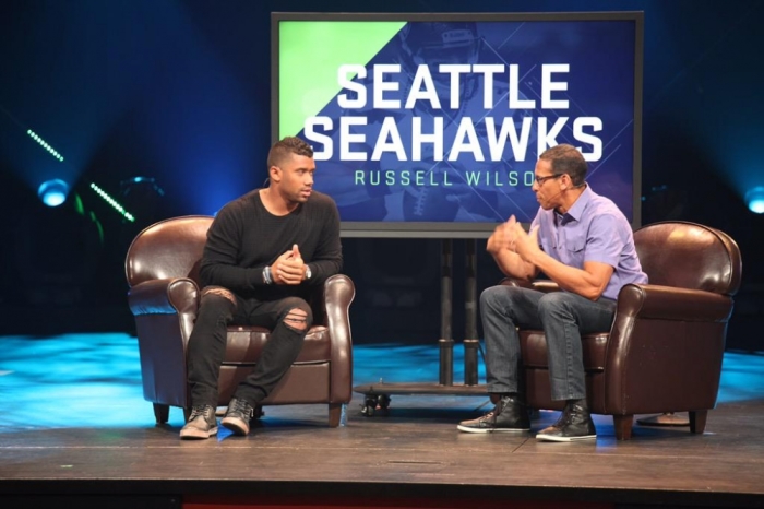 Seattle Seahawks quarterback Russell Wilson speaks with pastor Miles McPherson from The Rock Church in San Diego, California, on Sunday, June 5, 2015.