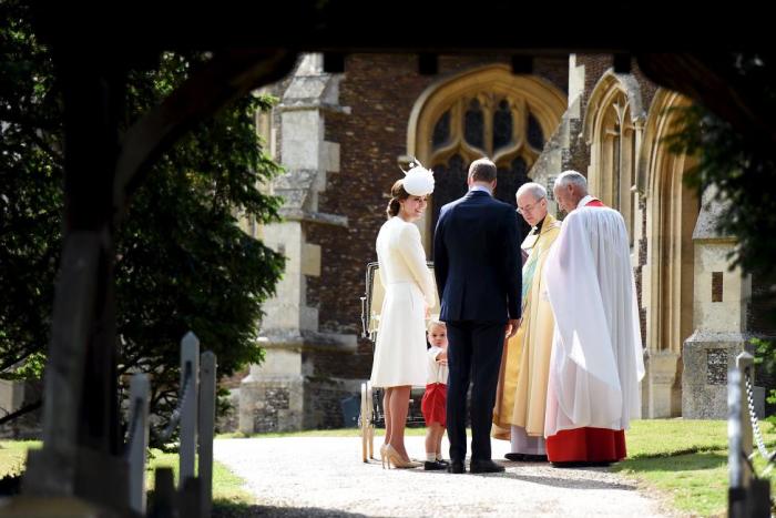 Prince George turns to look at the crowds as Princess Charlotte, Prince William and Catherine, Duchess of Cambridge are greeted by Reverend Canon Jonathan Riviere and the Archbishop of Canterbury, Justin Welby, at St Mary Magdalene on the Sandringham Estate for the christening of the princess on July 5th 2015.