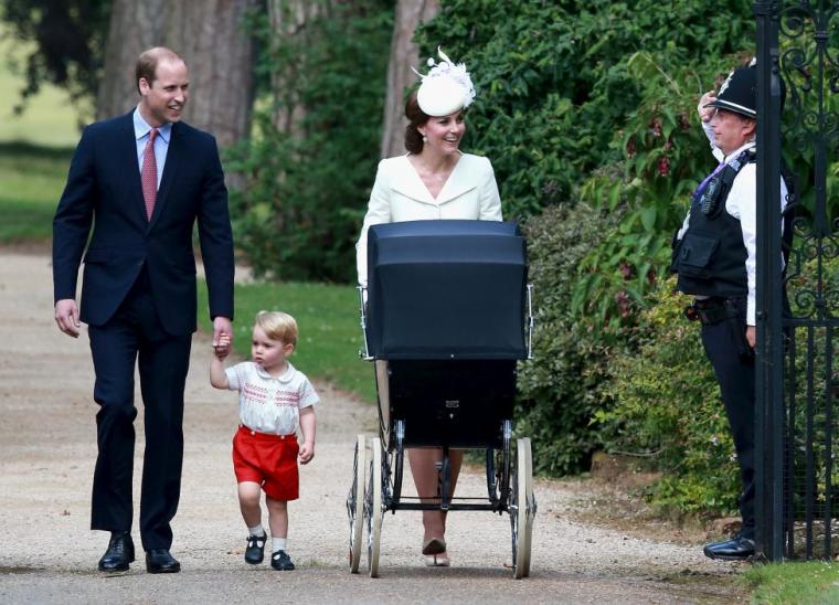 Catherine, Duchess of Cambridge, Prince William, Duke of Cambridge, Princess Charlotte of Cambridge and Prince George of Cambridge are saluted by a policeman as they arrive at the Church of St Mary Magdalene on the Sandringham Estate for the christening of Princess Charlotte of Cambridge on July 5, 2015.