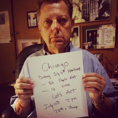 Chicago Priest Michael Pfleger holds up sign displaying the number of murders during 4th of July weekend, 2014.