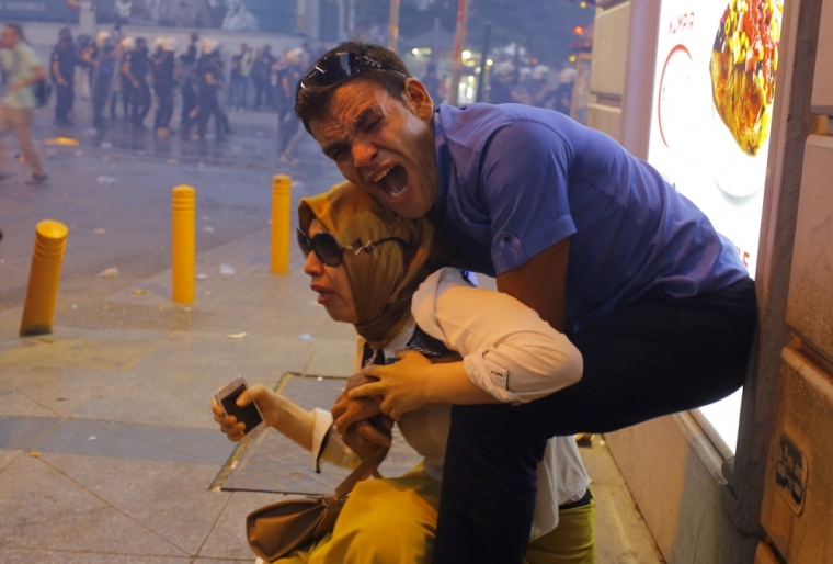 A couple, affected by tear gas used by riot police to disperse demonstrators, reacts in central Istanbul, Turkey, July 20, 2015. Police in Istanbul fired teargas and water cannon when a demonstration by protesters blaming the government for a suspected Islamic State suicide bombing turned violent, a Reuters witness said. Hundreds gathered near Istanbul's central Taksim Square after the bombing in the mostly Kurdish border town of Suruc which killed at least 30 people. Some chanted slogans against President Tayyip Erdogan and the ruling AK Party, including: 'Murderer Islamic State, collaborator Erdogan and AKP.' Turkey's Kurds have been enraged by what they see as Ankara's failure to do more to stop Islamic State. The PKK Kurdish militant group earlier said it held the government responsible for Monday's attack, saying Ankara had 'supported and cultivated' Islamic State against the Kurds in Syria. The demonstration in Istanbul had largely been peaceful, but some protesters threw bottles at police, the witness said.