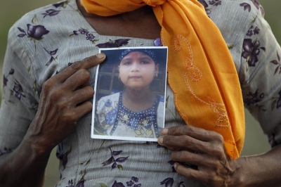 Rohiakar, a Rohingya Muslim woman, shows a picture of her daughter Saywar Nuyar, 22, who is being held by a human trafficker, at a refugee camp outside Sittwe, Myanmar May 21, 2015. Picture taken May 21, 2015.