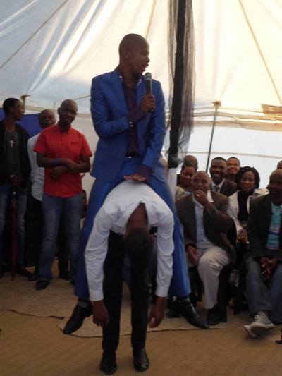 Self-styled South African prophet Penuel Mnguni, 24, rides one of his congregants like a horse.