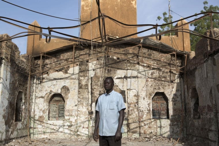 Churchgoer Romain Oke poses for a picture inside an evangelical church that was destroyed in riots demonstrating against French satirical magazine Charlie Hebdo's cartoons of the Islamic prophet Muhammad, in Niamey, Niger, January 23, 2015. At least five people were killed last Saturday in protests in Niger against Charlie Hebdo's cartoons of the Muslim prophet Muhammad, authorities said, bringing the death toll from two days of violence in the country to 10.