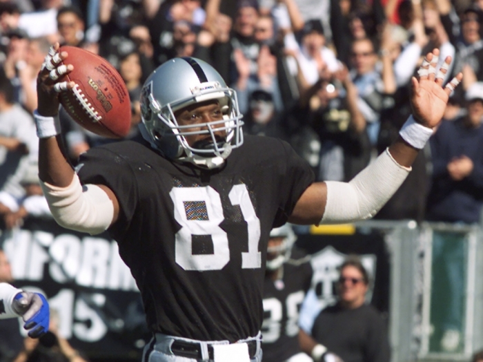 Oakland Raiders tight end Tim Brown (81) raises his arms after catching a nine-yard touchdown pass from Raiders quaterback Rich Gannon in the second quarter of a game at Network Associates Coliseum October 22, 2000. The touchdown catch was Brown's second of the game.