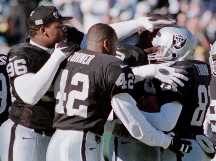 Oakland Raiders' WR Tim Brown (R) is congratulated by team mates Darnell Russell (96) and Eric Turner (42) after Brown set a new Raiders' franchise record for career catches by a catching a pass from Raiders QB Jeff George in the first period of the game against the Jacksonville Jaguars at the Oakland Coliseum, December 21. Brown had 14 catches for 164 yards, the most receptions in Raiders' history.