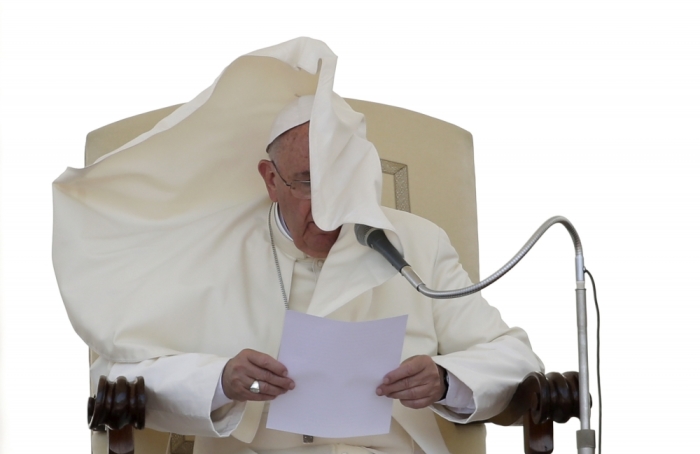 A gust of wind blows the mantle of Pope Francis as he leads his Wednesday general audience in Saint Peter's square at the Vatican, June 17, 2015.