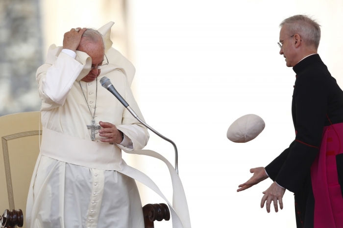 A gust of wind blows Pope Francis's skull cap off during his Wednesday general audience in Saint Peter's square at the Vatican, May 20, 2015.