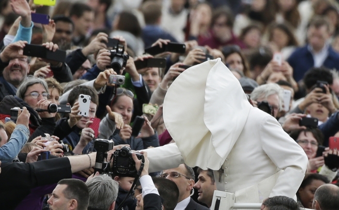 A gust of wind blows Pope Francis's mantle as he arrives to lead his Wednesday general audience in Saint Peter's square at the Vatican, February 19, 2014.