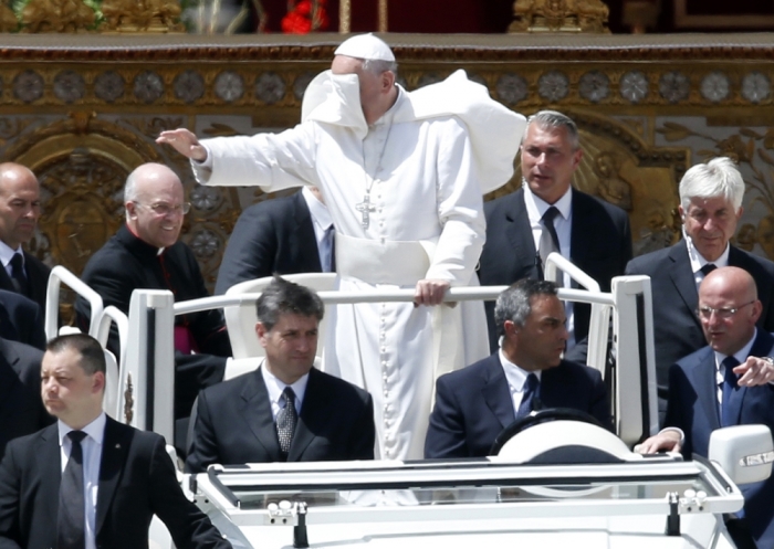 A gust of wind blows Pope Francis' mantle as he leaves at the end of a mass in Saint Peter's Square at the Vatican, May 19, 2013.