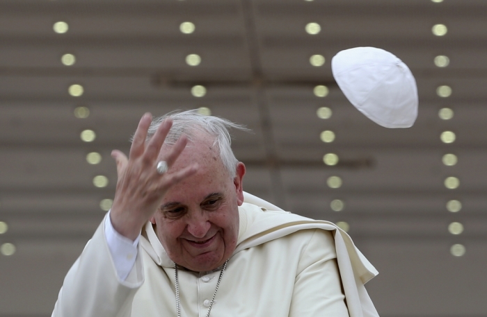 A gust of wind blows off Pope Francis' cap during his weekly general audience at St. Peter's Square at the Vatican, April 30, 2014.