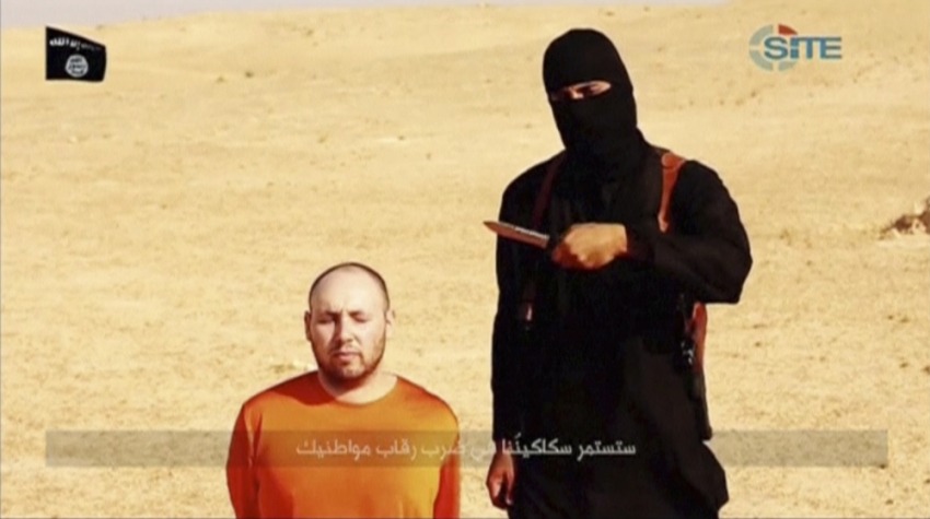 A masked, black-clad militant, who has been identified by the Washington Post newspaper as a Briton named Mohammed Emwazi, stands next to a man purported to be Steven Sotloff in this still image from a video obtained from SITE Intel Group website February 26, 2015. The "Jihadi John" killer who has featured in several Islamic State beheading videos is Emwazi, a Briton from a middle class family who grew up in London and graduated from college with a degree in computer programming, the Washington Post newspaper said. In videos released by Islamic State the masked, black-clad militant brandishing a knife and speaking with an English accent appears to have carried out the beheadings of hostages including Americans and Britons.