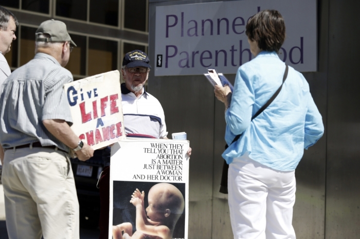 Abortion protesters stand in front of a Planned Parenthood clinic in Boston, Massachusetts, June 27, 2014. The U.S. Supreme Court handed a victory to anti-abortion activists on Thursday by making it harder for states to enact laws aimed at helping patients entering abortion clinics to avoid protesters, striking down a Massachusetts statute that had created a no-entry zone.