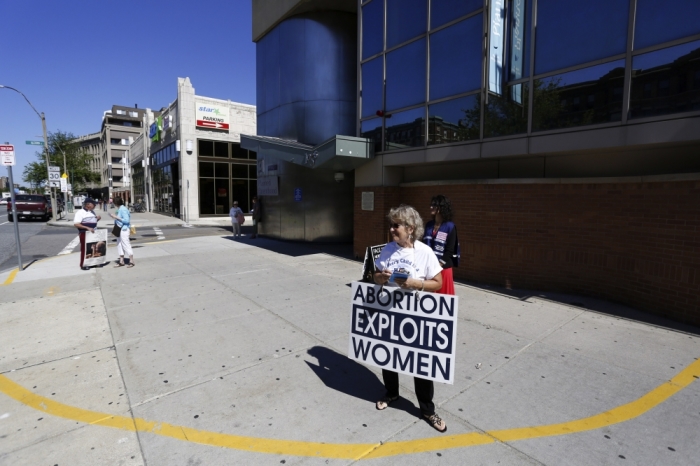 Abortion protesters stand in front of a Planned Parenthood clinic in Boston, Massachusetts, June 27, 2014. The U.S. Supreme Court handed a victory to pro-life activists on Thursday by making it harder for states to enact laws aimed at helping patients entering abortion clinics to avoid protesters, striking down a Massachusetts statute that had created a no-entry zone.