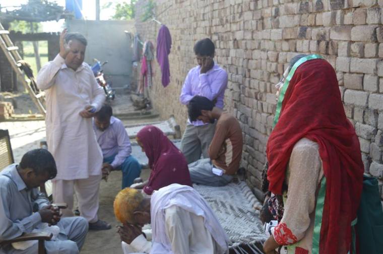 The family of Fouzia Sadiq meet with BPCA officer Bhatti at the family's living quarters in the Punjab province of Pakistan.