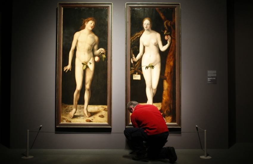 A museum worker cleans the floor in front of true to scale copies of the paintings "Adam" and "Eve" by Hans Baldung Grien, the apprentice of German Renaissance painter Albrecht Duerer, during a pre-view of the Duerer exhibition at the Staedel museum in Frankfurt October 22, 2013. 