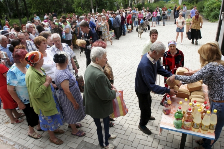 Local residents stand in a line during a distribution of free bread in Donetsk, Ukraine, July 3, 2015.