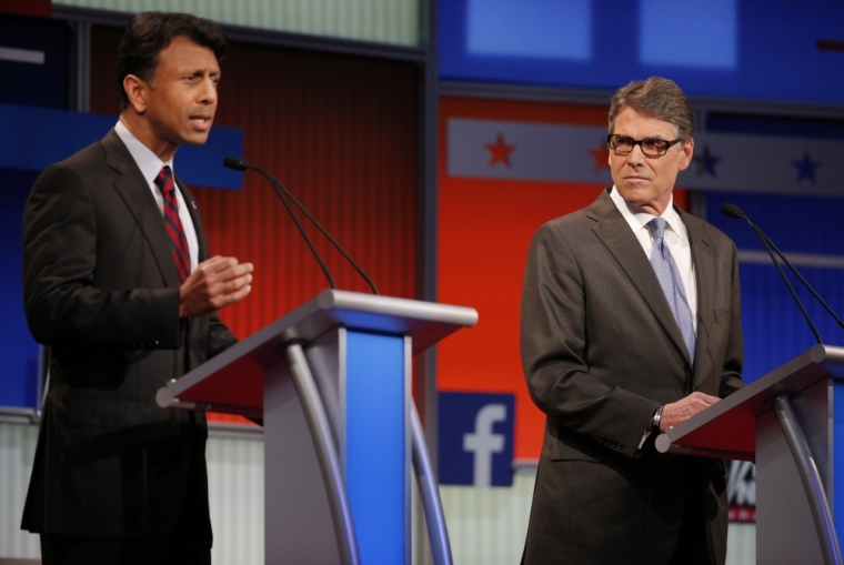 Republican presidential candidate and Louisiana Governor Bobby Jindal (L) answers a question as former Texas Governor Rick Perry (R) listens at a Fox-sponsored forum for lower polling candidates held before the first official Republican presidential candidates debate of the 2016 U.S. presidential campaign in Cleveland, Ohio, August 6, 2015.