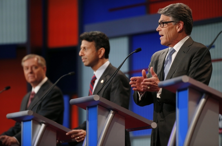 Former Republican presidential candidate and Texas Governor Rick Perry (R) responds to a question as U.S. Senator Lindsey Graham (L) and Louisiana Governor Bobby Jindal (C) listen at a Fox-sponsored forum for lower polling candidates held before the first official Republican presidential candidates debate of the 2016 U.S. presidential campaign in Cleveland, Ohio, August 6, 2015.