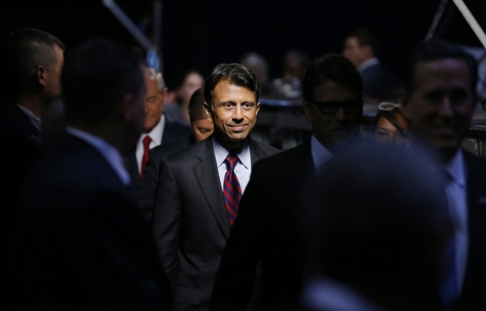 Republican presidential candidate and Louisiana Governor Bobby Jindal (C) arrives on stage along with former Virginia Governor Jim Gilmore (L) and former Texas Governor Rick Perry (2nd R) and former U.S. Senator Rick Santorum (R) before the start of a Fox-sponsored forum for lower polling candidates held before the first official Republican presidential candidates debate of the 2016 U.S. presidential campaign in Cleveland, Ohio, August 6, 2015.