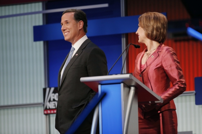Republican presidential candidates, former U.S. Senator Rick Santorum and former HP CEO Carly Fiorina, talk in the midst of a commercial break at a Fox-sponsored forum for lower polling candidates held before the first official Republican presidential candidates debate of the 2016 U.S. presidential campaign in Cleveland, Ohio, August 6, 2015.
